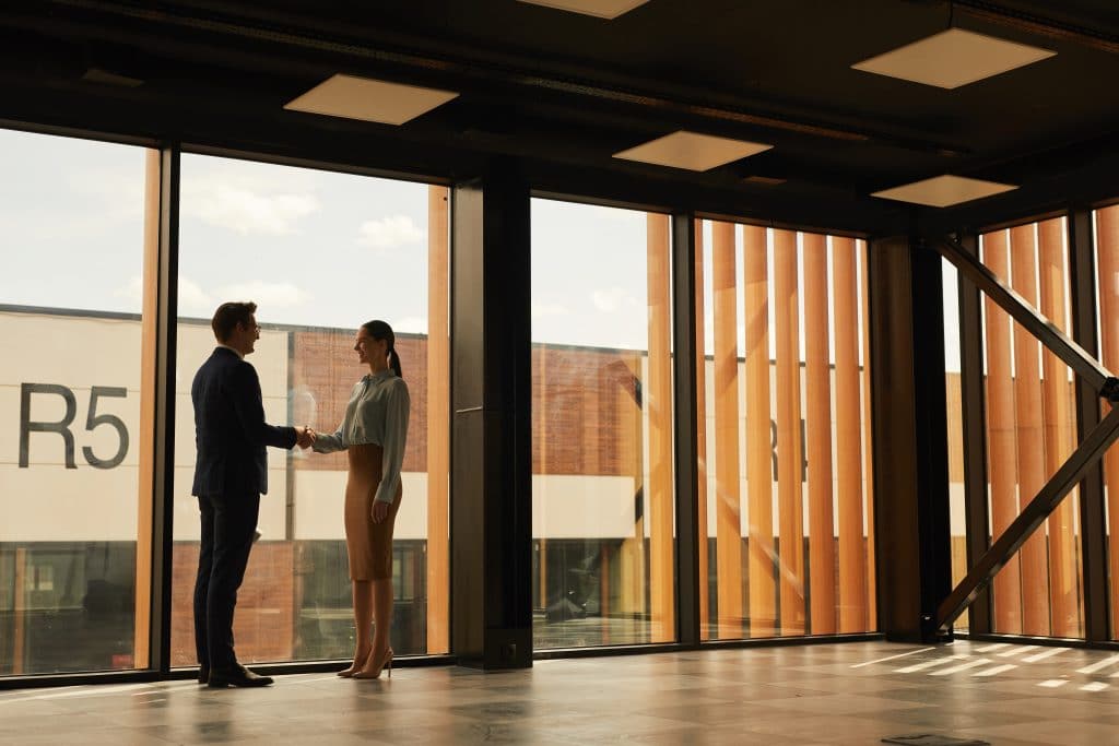 man and woman shaking hands in a commerical building