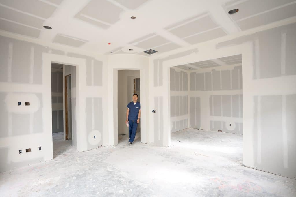 Empty unfinished home with a man standing in the corner