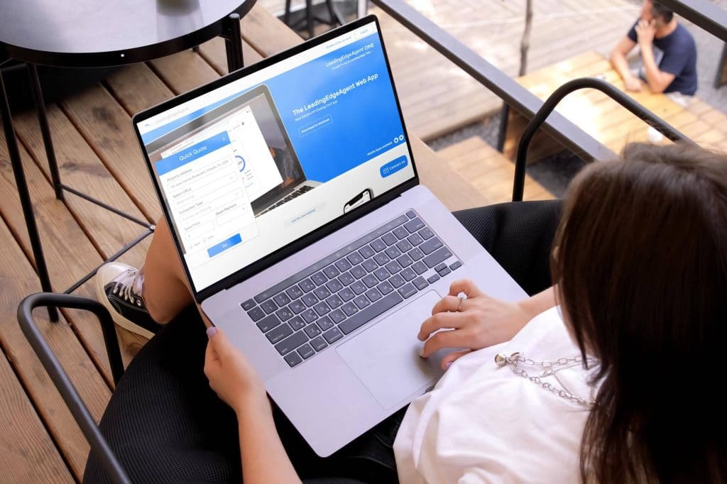 Woman holding a laptop with the Leading Edge Title website pulled up