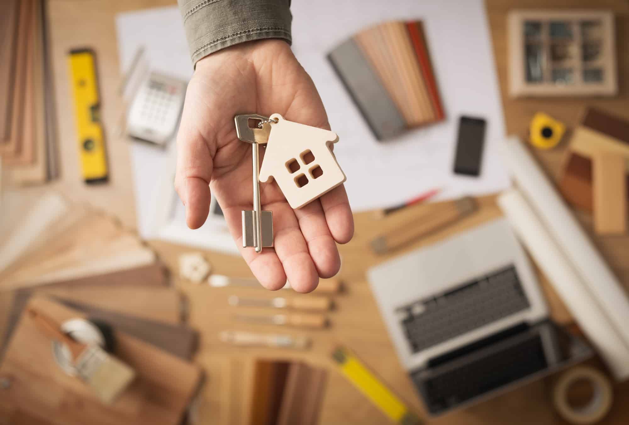 homeowner handing over a house key after for sale by owner closing