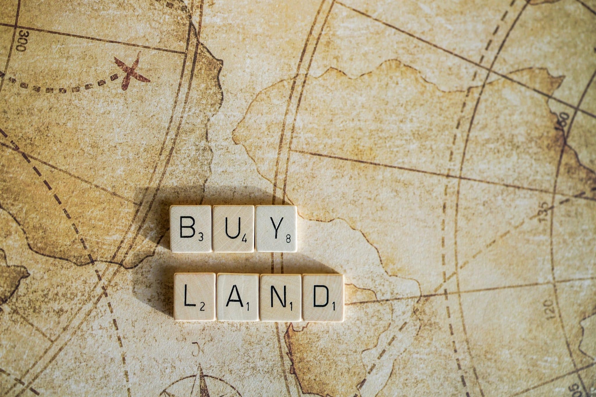 Buy Land sign on old world map