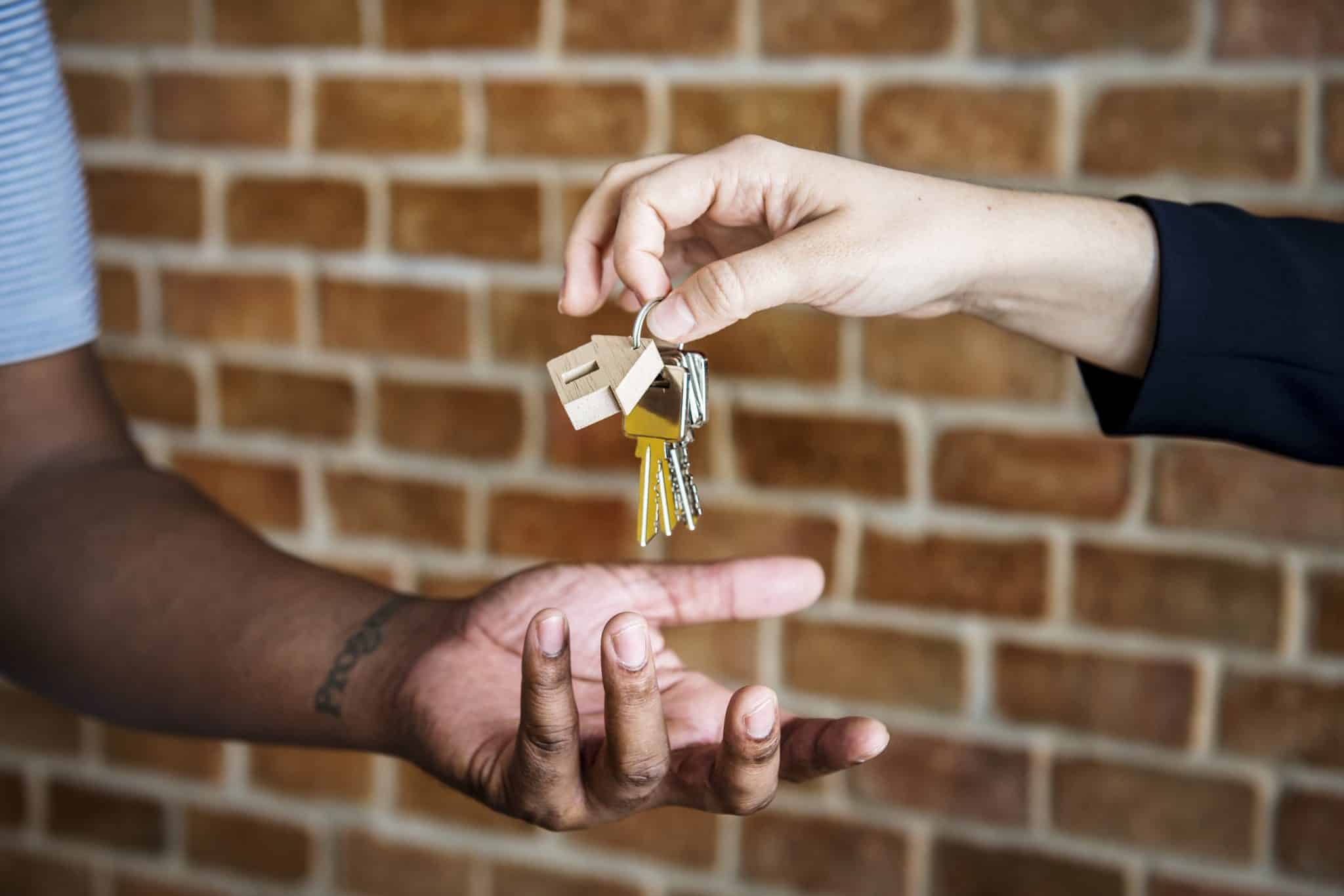 Real estate professional handing keys to new home over to buyer
