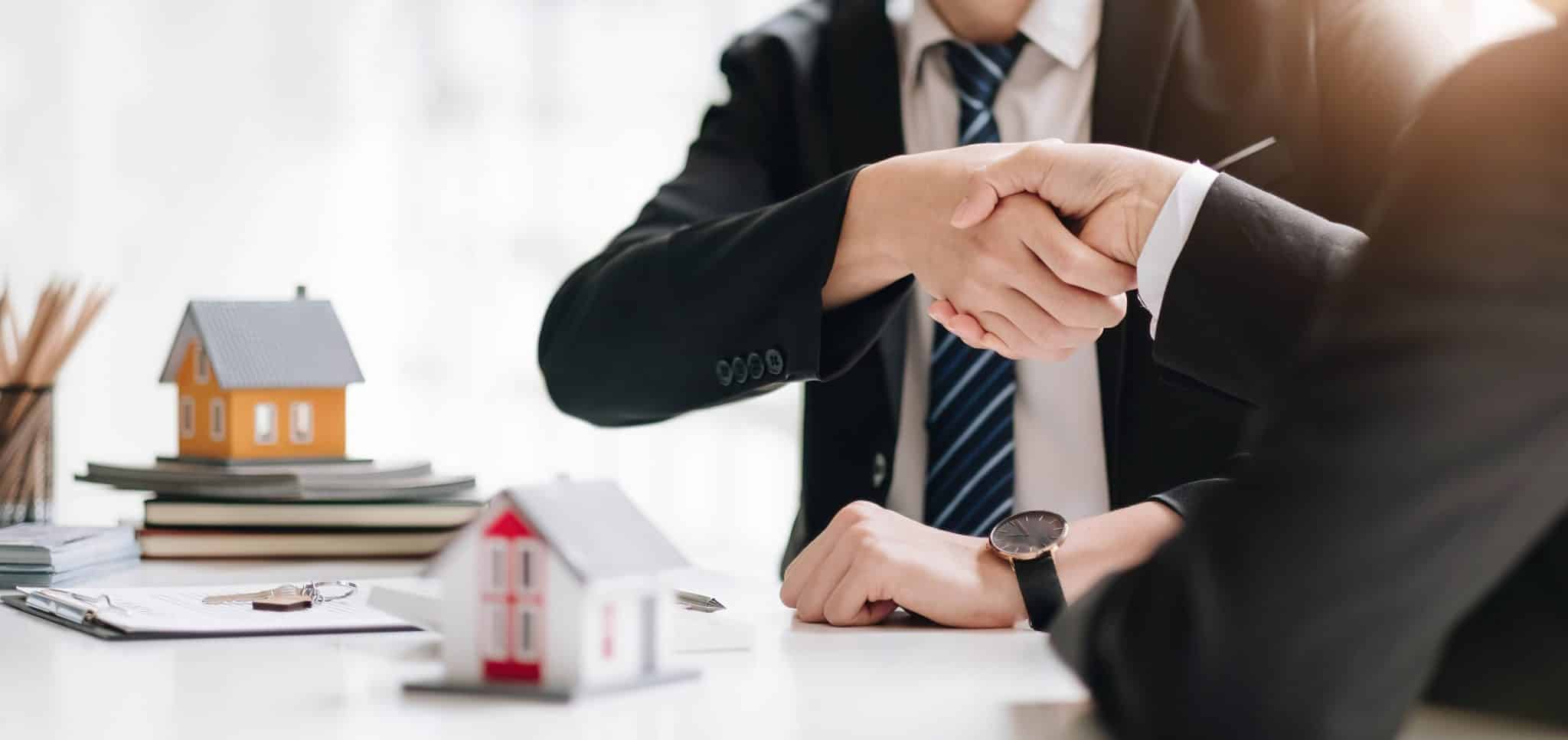 Title company agent shaking hands with real estate buyer
