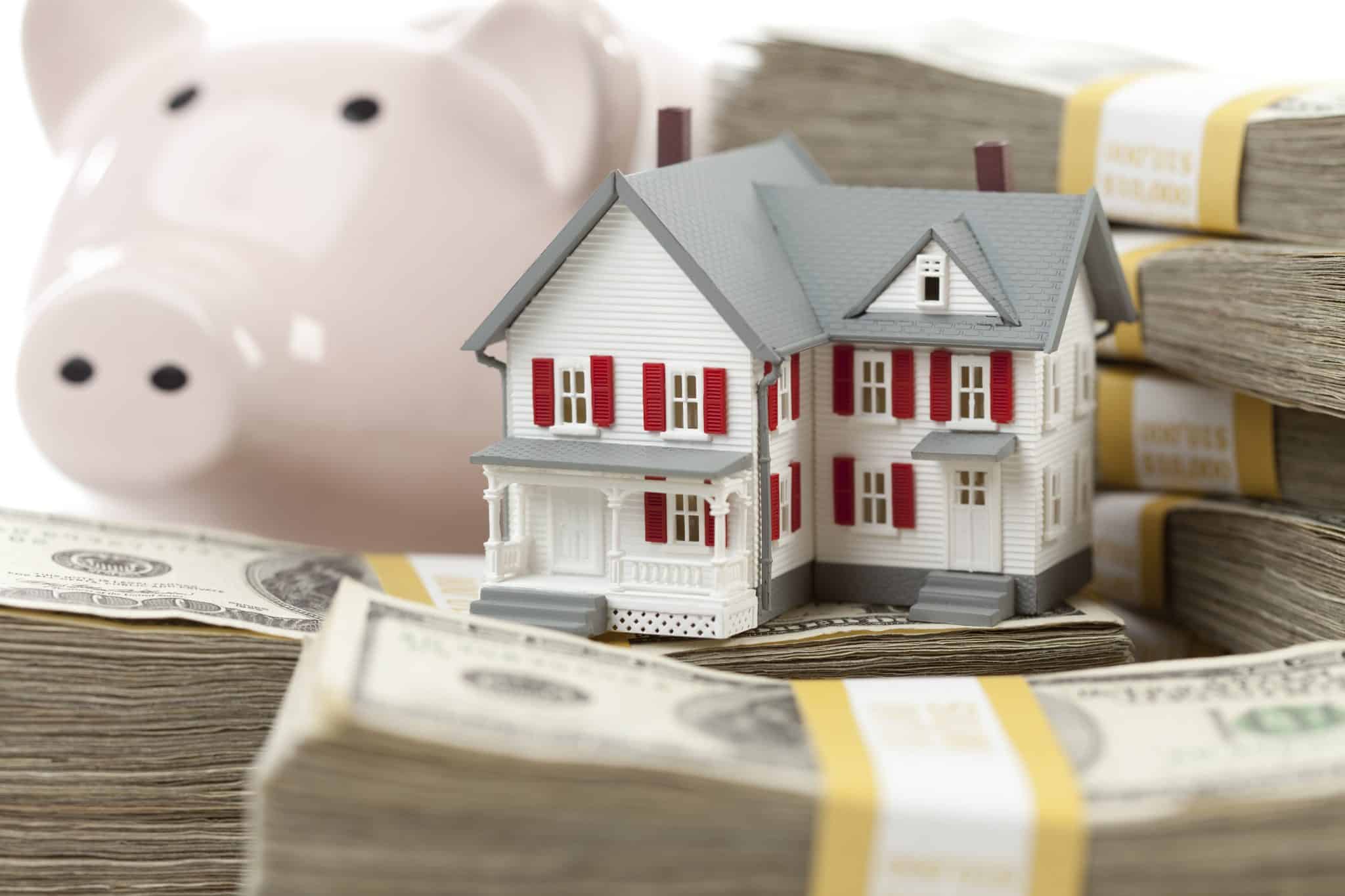 What is Escrow? - small model of house next to piggy bank and stacks of cash