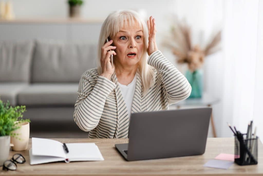 Mature woman looking shocked while on the phone