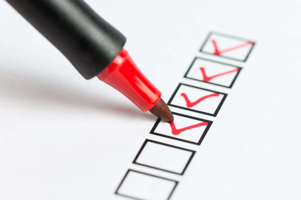 A refinancing checklist being marked with a red pen.
